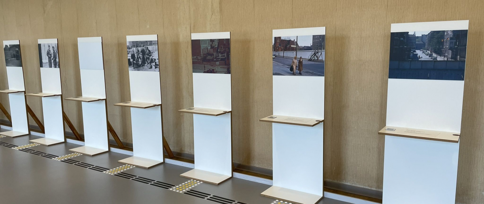 Ansicht der Ausstellung - eine Reihe von Bildern auf Podesten ist zu sehen.